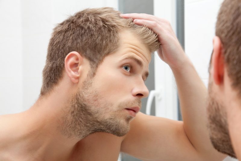 Man Checking Hairline in Mirror Man Checking Hairline in Mirror