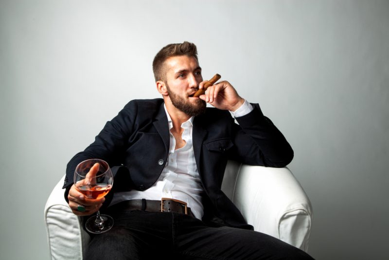 Man with Cigar Wearing Sport Coat and White Shirt Holding Glass of Wine