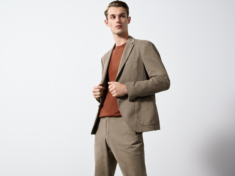 In front and center, Kit Butler dons a cotton slim-fit suit with a 100% merino wool sweater.