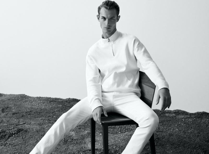 Dressed in white, Kit Butler wears a mock neck sweater with slim-fit jeans from Massimo Dutti's Join Life collection.