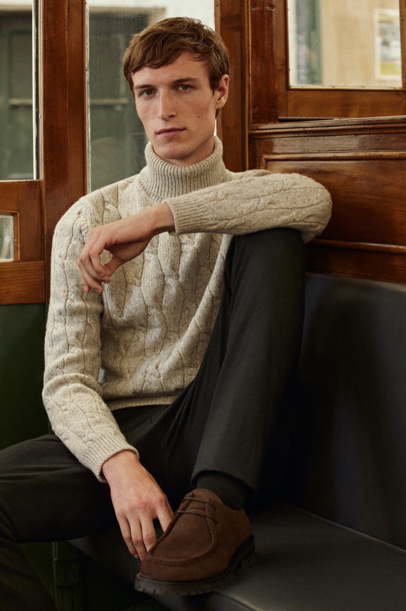 In front and center, Egon Van Praet models a Massimo Dutti cable-knit sweater with trousers.