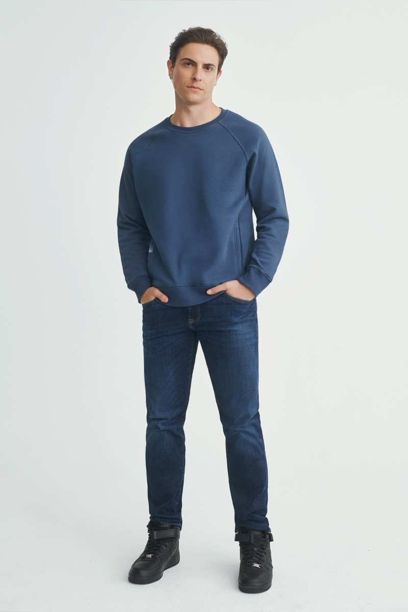 Actor Derek Klena wears a blue sweatshirt with jeans from Mavi's fall-winter 2021 collection.