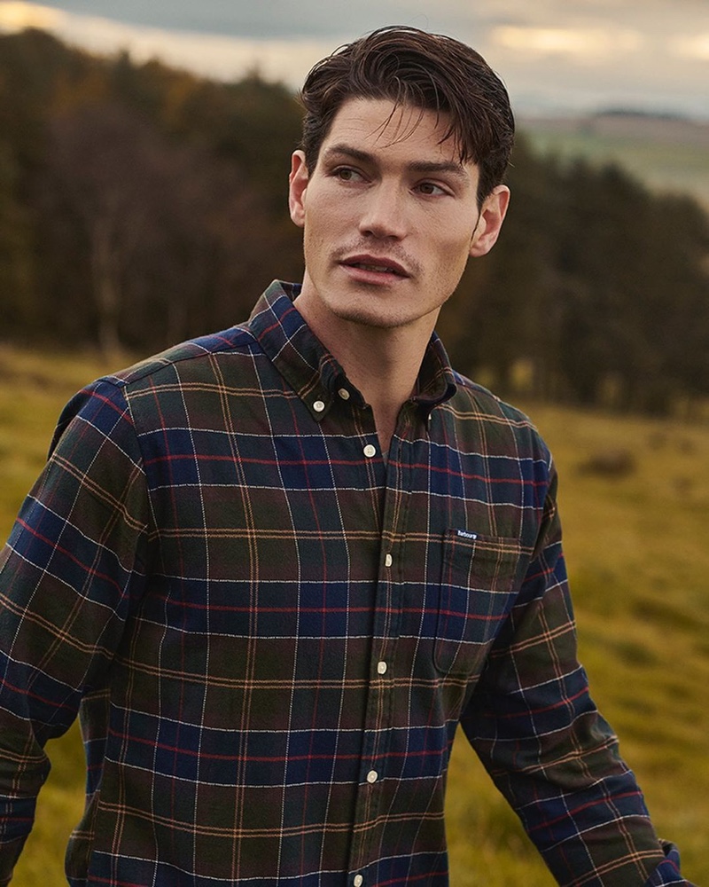 Venturing outdoors, Sam Way sports a tartan shirt from Barbour.