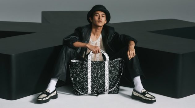 Jimmy Choo Delivers a Modern Attitude with Eric Haze Collaboration Posing with an oversized bag, Yudai Tateishi wears printed black and white loafers from the Jimmy Choo x Eric Haze collection.