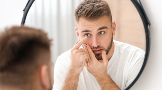 Things to Consider Before Using Eye Contacts Man Using Eye Contacts Mirror