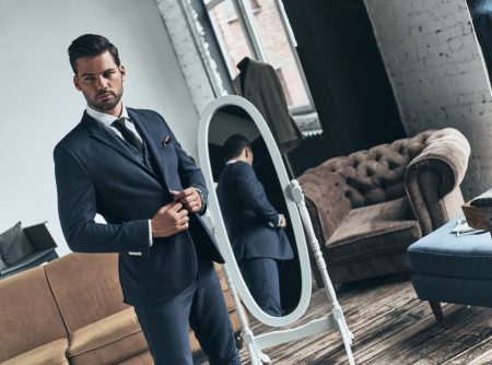 Man Wearing Suit in Front of Mirror