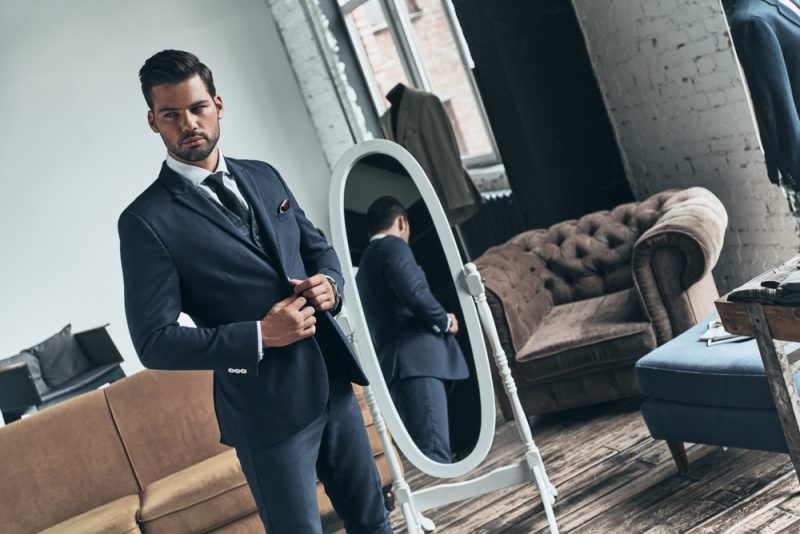 Man Wearing Suit in Front of Mirror