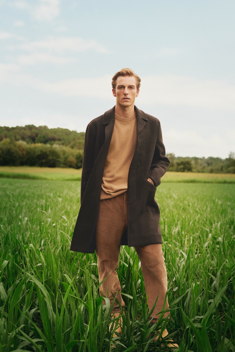 Quentin Demeester dons a single-breasted coat with a crewneck sweater and corduroy pants by Mango.