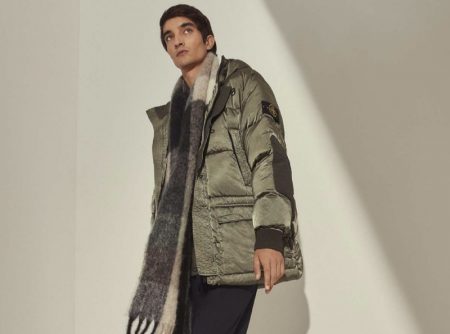 Bundling up for winter, Pablo Fernandez models a Stone Island nylon raso down-TC jacket with an Acne Studios alpaca-blend checked scarf, Bottega Veneta BV tire leather boots, and a Canada Goose sweater.