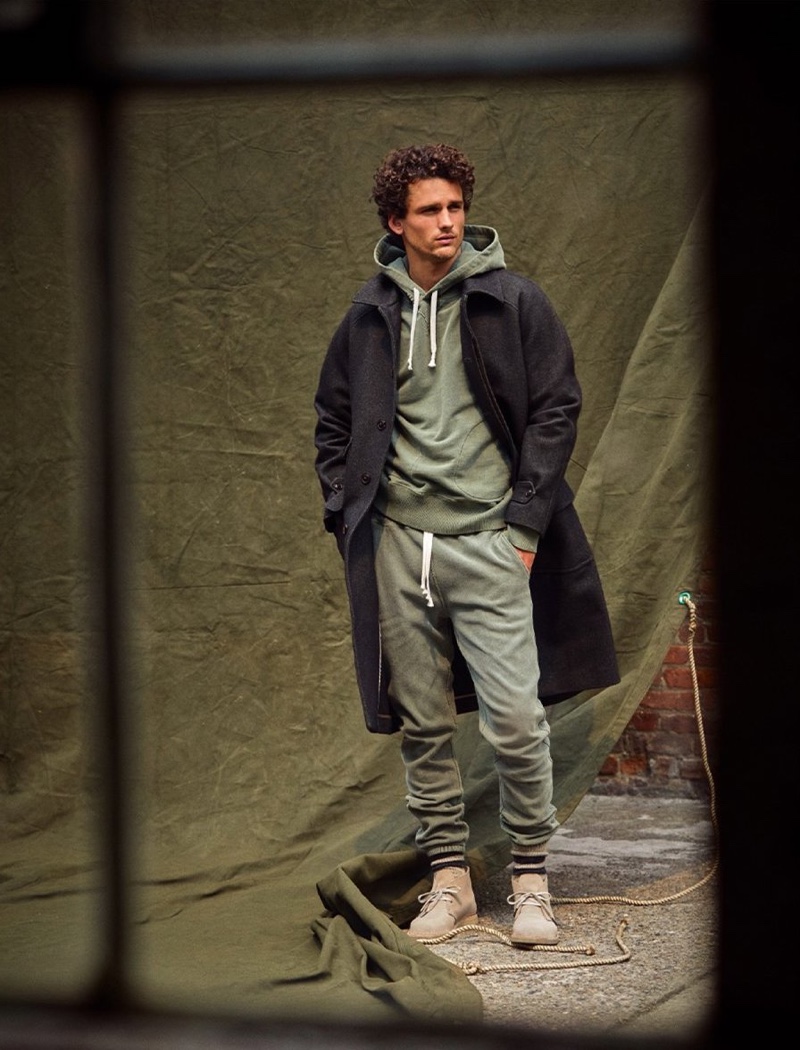 A sporty vision, Simon Nessman rocks a garment dyed hoodie and classic sweatpants with an Italian pressed donegal overcoat by Todd Snyder.