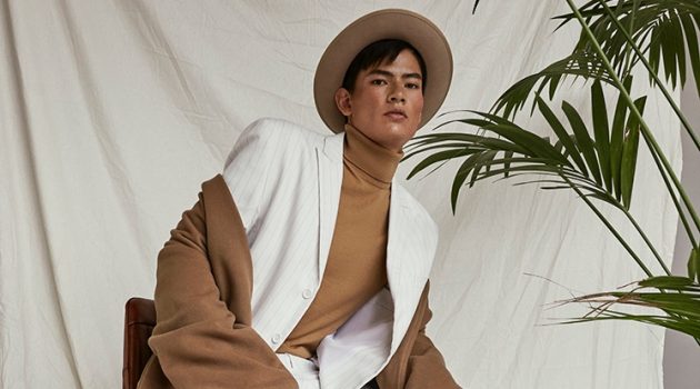 Simonas Pham in 'New Elegance' Simonas wears suit Eleventy, pullover Ermenegildo Zegna, coat Franziska Michael, hat Stetson, belt Drykorn, and shoes Red Wing.
