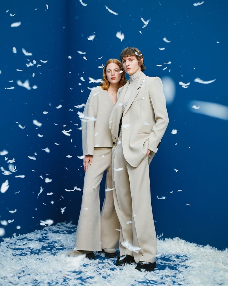Models Julia Banas and Henry Rausch sport neutral-colored tailoring from AMI Paris' fall-winter 2021 collection.