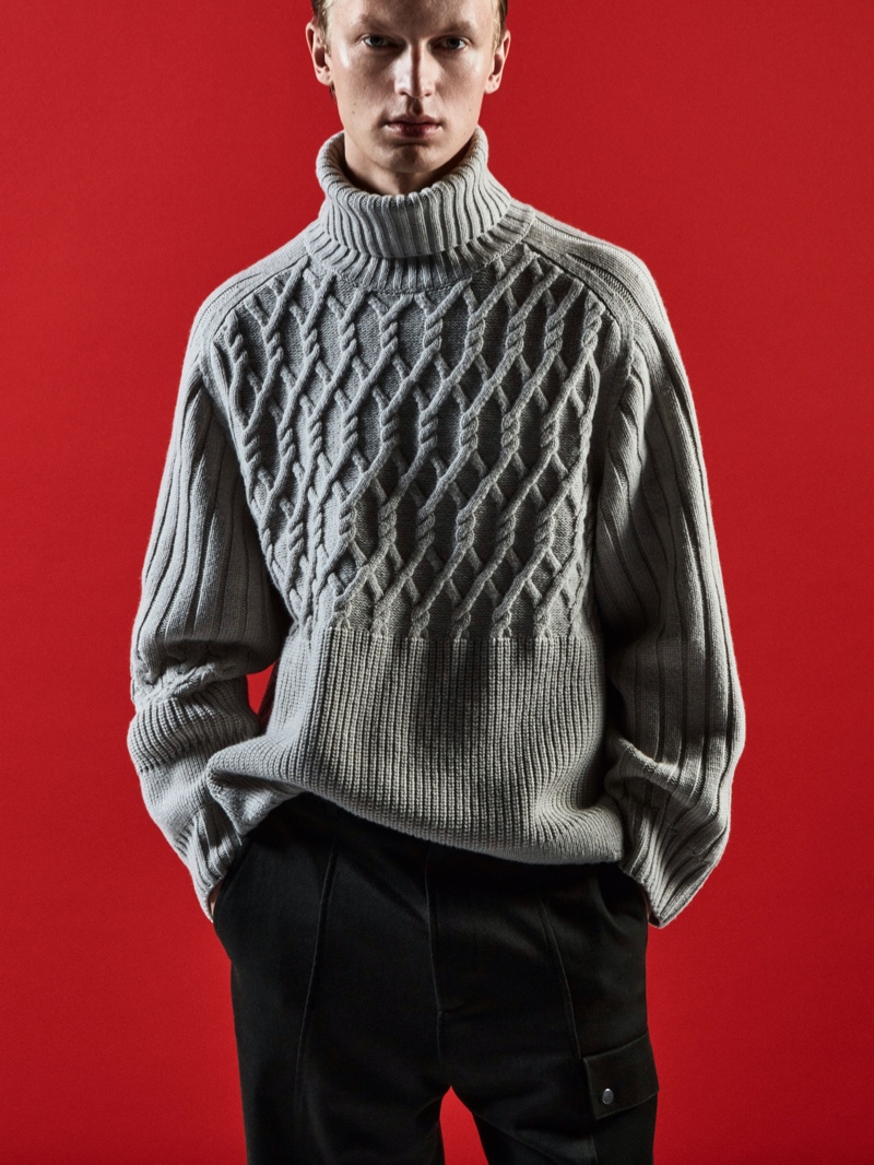 In front and center, Jonas Glöer wears a cable-knit sweater with cargo pants for COS's holiday 2021 campaign.