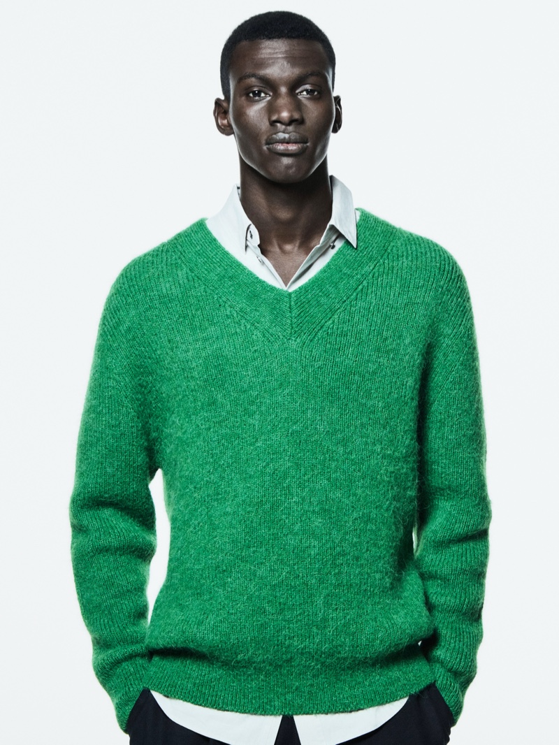 Getting in the festive spirit, Momo Ndiaye wears a green v-neck sweater for COS's holiday 2021 campaign.