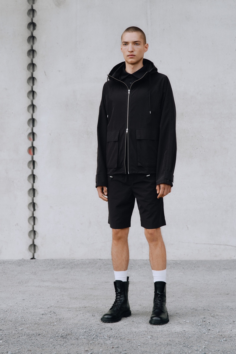 In front and center, David Shyn rocks a windbreaker jacket with shorts and lace-up boots from Filippa K's spring-summer 2022 men's collection.