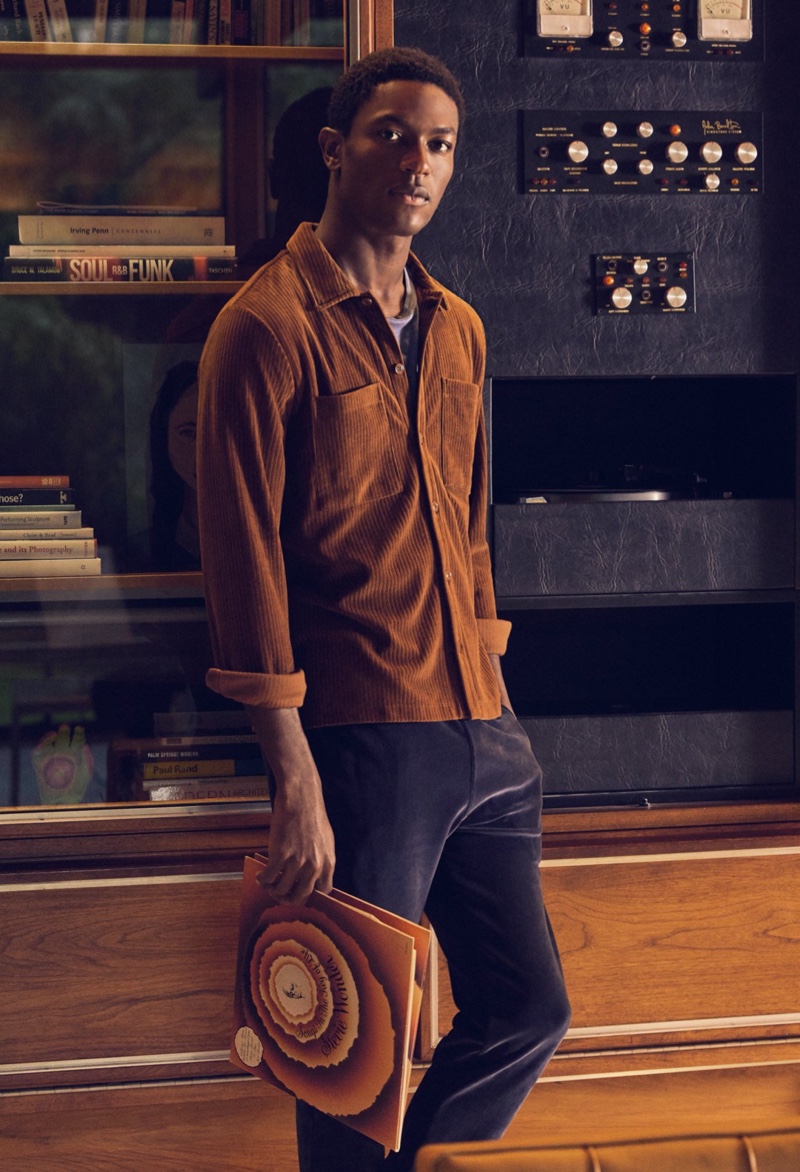 Embracing an earthy shade in rust, Hamid Onifade models Todd Snyder's ribbed velour button-down shirt with slim-fit 5-pocket chinos.