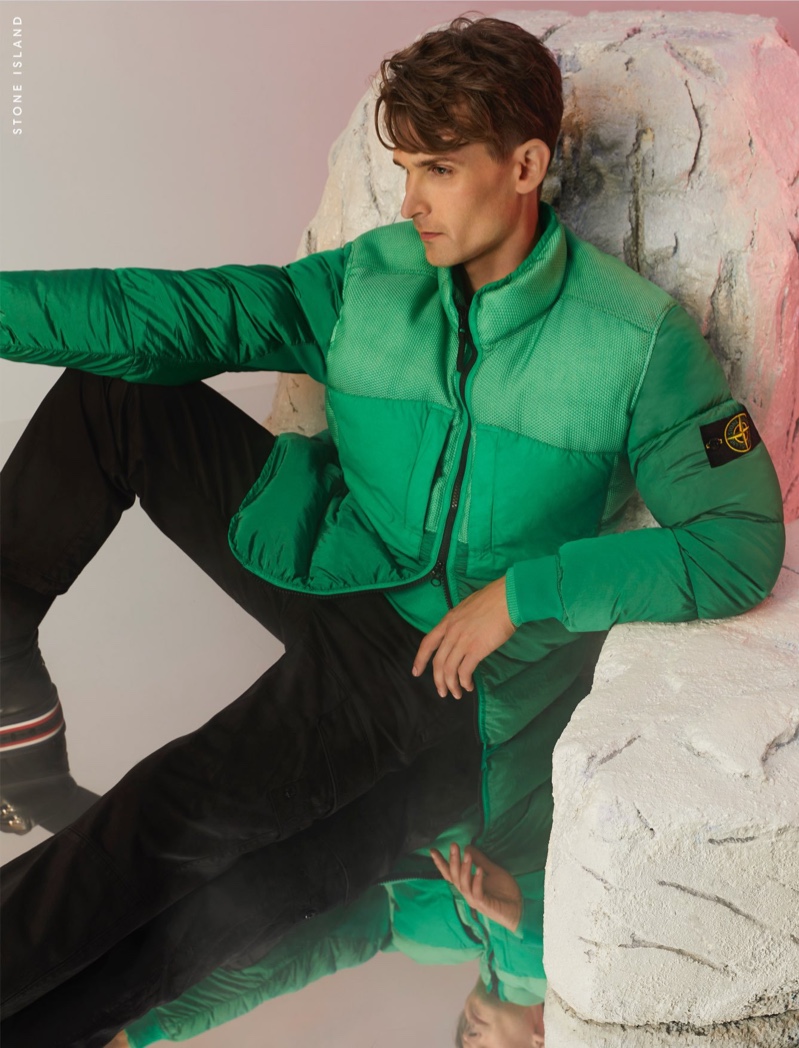 Stirring up envy, Lowell Tautchin poses in a green Stone Island jacket for Holt Renfrew.