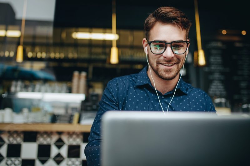 Man Wearing Glasses Smiling on Laptop