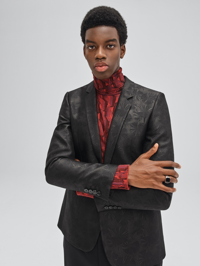 In a festive 2021 campaign for Mytheresa, Cedric Sanvee sports an embroidered suit with a graphic turtleneck.