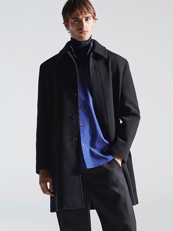 Dutch model Parker van Noord dons a turtleneck with a shirt, coat, and wide-leg trousers from COS.