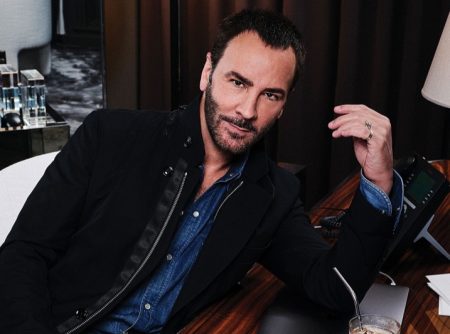 Designer Tom Ford poses at his desk for a photo.