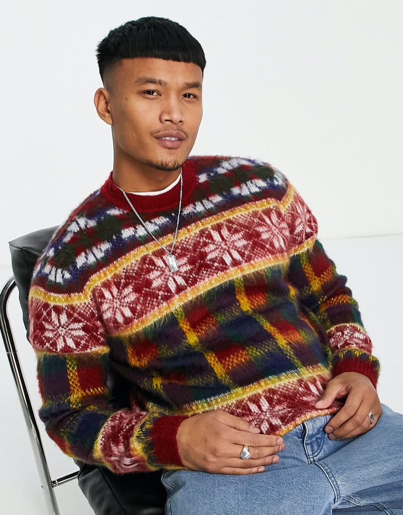 Model Zak Srakaew dons a fluffy knit Christmas sweater with a tartan design by ASOS.