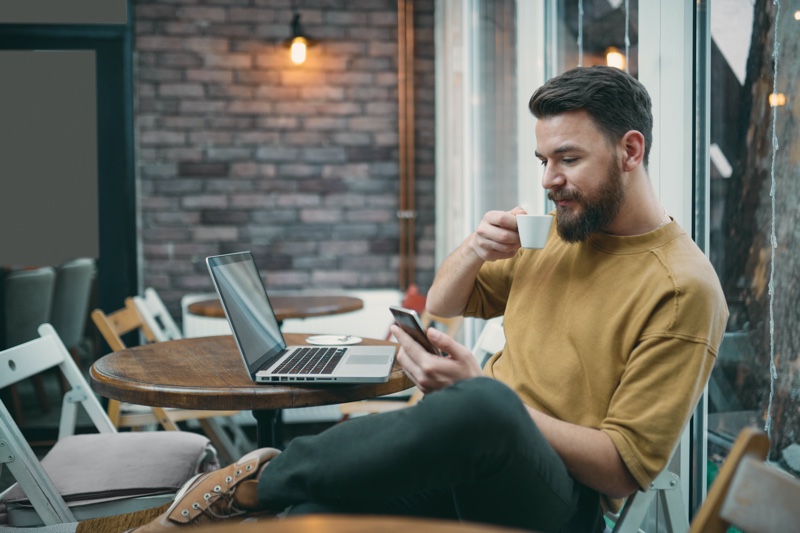 Attractive Man Cafe Checking Phone Laptop