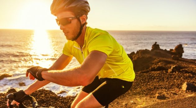 Here's Why Athletes Should Wear a Sports Watch Cyclist Riding Bike Checking Watch Yellow Shirt
