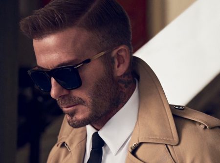 Pictured in a trench coat, David Beckham models DB 7066/F/S sunglasses.