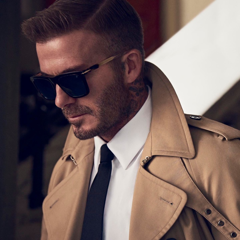 Pictured in a trench coat, David Beckham models DB 7066/F/S sunglasses.