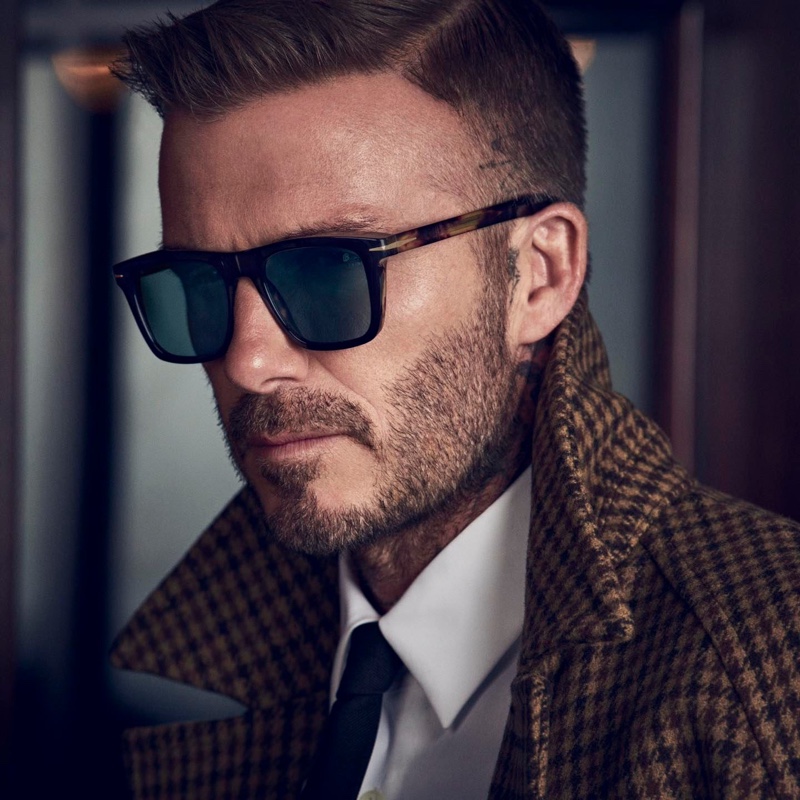 Donning a herringbone coat, David Beckham wears DB 7000/S sunglasses.