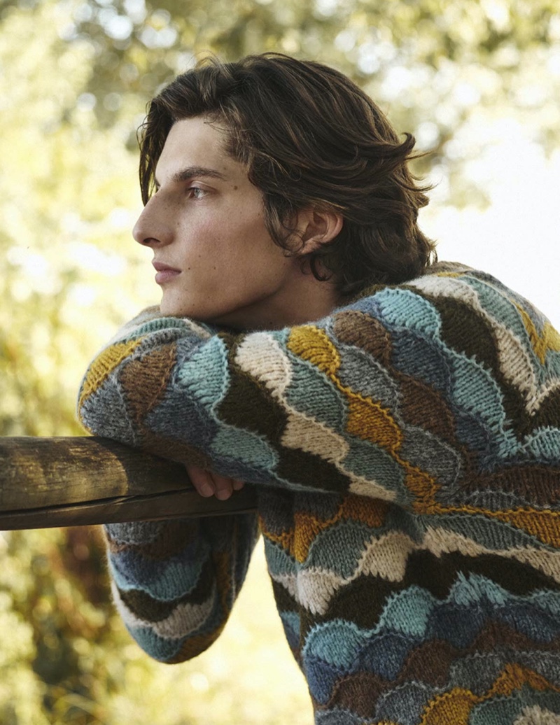 Caught daydreaming, Hugo Gillain wears a Rainbow Mountain alpaca-blend sweater from Alanui for Mytheresa.