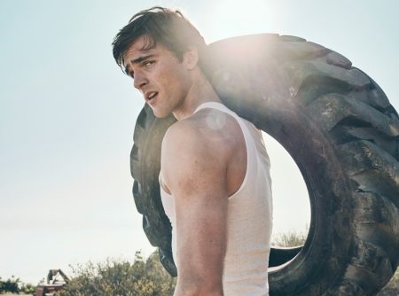 Carrying a tire, Jacob Elordi rocks a tank by The Society Archive with True Classic joggers.