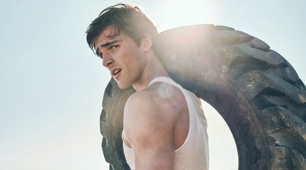 Euphoria Star Jacob Elordi Covers Men's Health, Talks Body Image Carrying a tire, Jacob Elordi rocks a tank by The Society Archive with True Classic joggers.