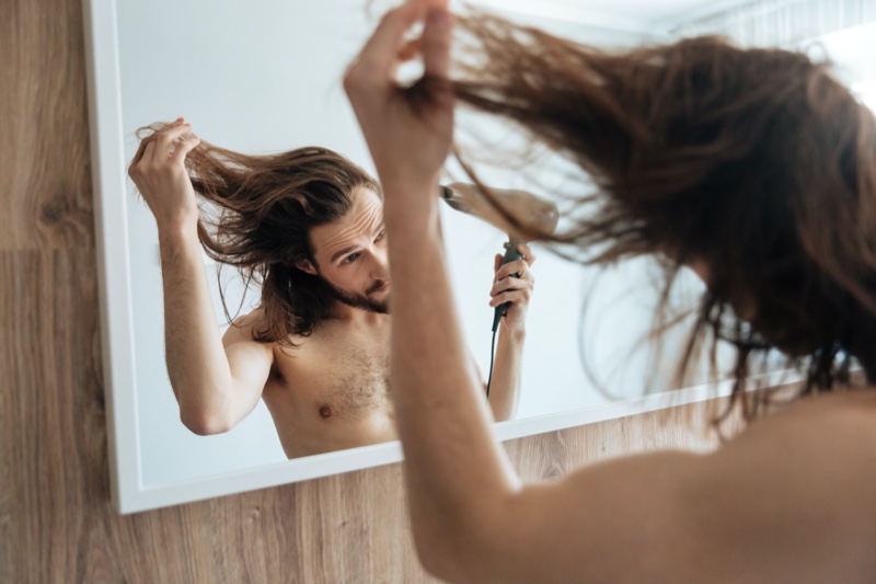 Man Blow Drying Long Hair Mirror
