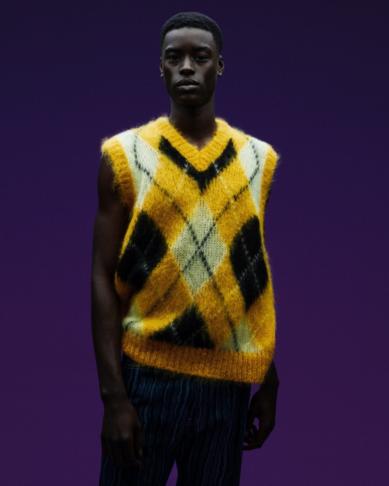 In front and center, Babacar N'doye wears a mohair-blend argyle print sweater vest from Marni for Mytheresa's cruise 2022 campaign.