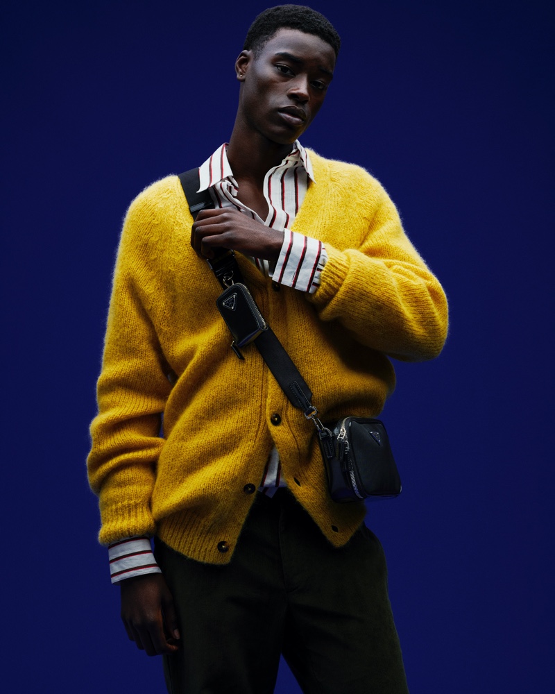 Donning a yellow Prada cardigan and accessories, Babacar N'doye stars in Mytheresa's resort 2022 campaign.