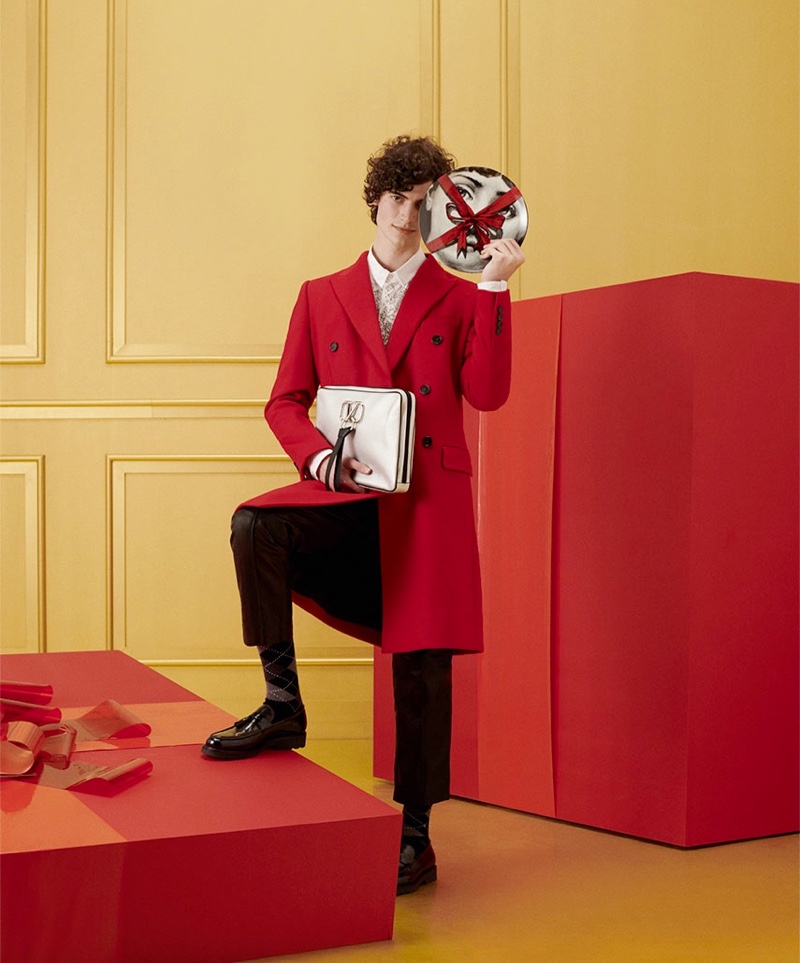 A dapper vision in a red coat, Geoffroy Noraz appears in YOOX's holiday 2021 gift guide.