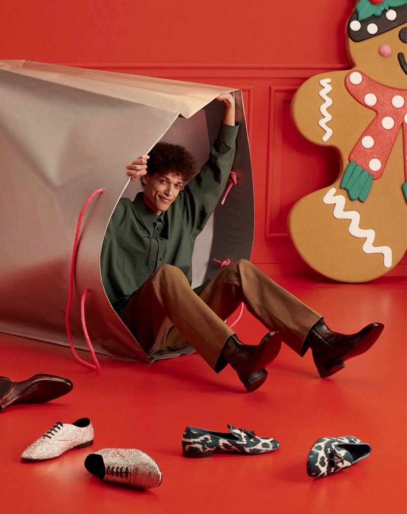 Model Marvin Spicher emerges from an oversized shopping bag for YOOX's holiday 2021 gift guide.