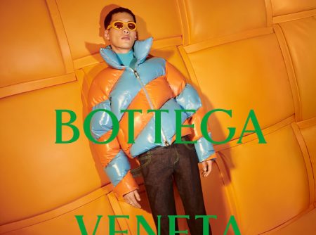 Wang Chenming models a tangerine and blue puffer jacket for Bottega Veneta's 2022 Chinese New Year campaign.