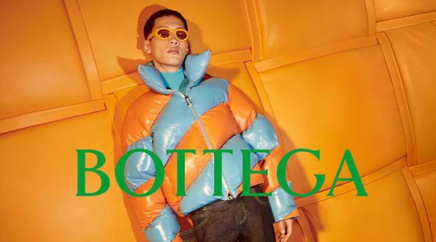 Wang Chenming models a tangerine and blue puffer jacket for Bottega Veneta's 2022 Chinese New Year campaign.