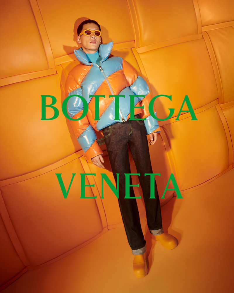 Wang Chenming models a tangerine and blue puffer jacket for Bottega Veneta's 2022 Chinese New Year campaign.