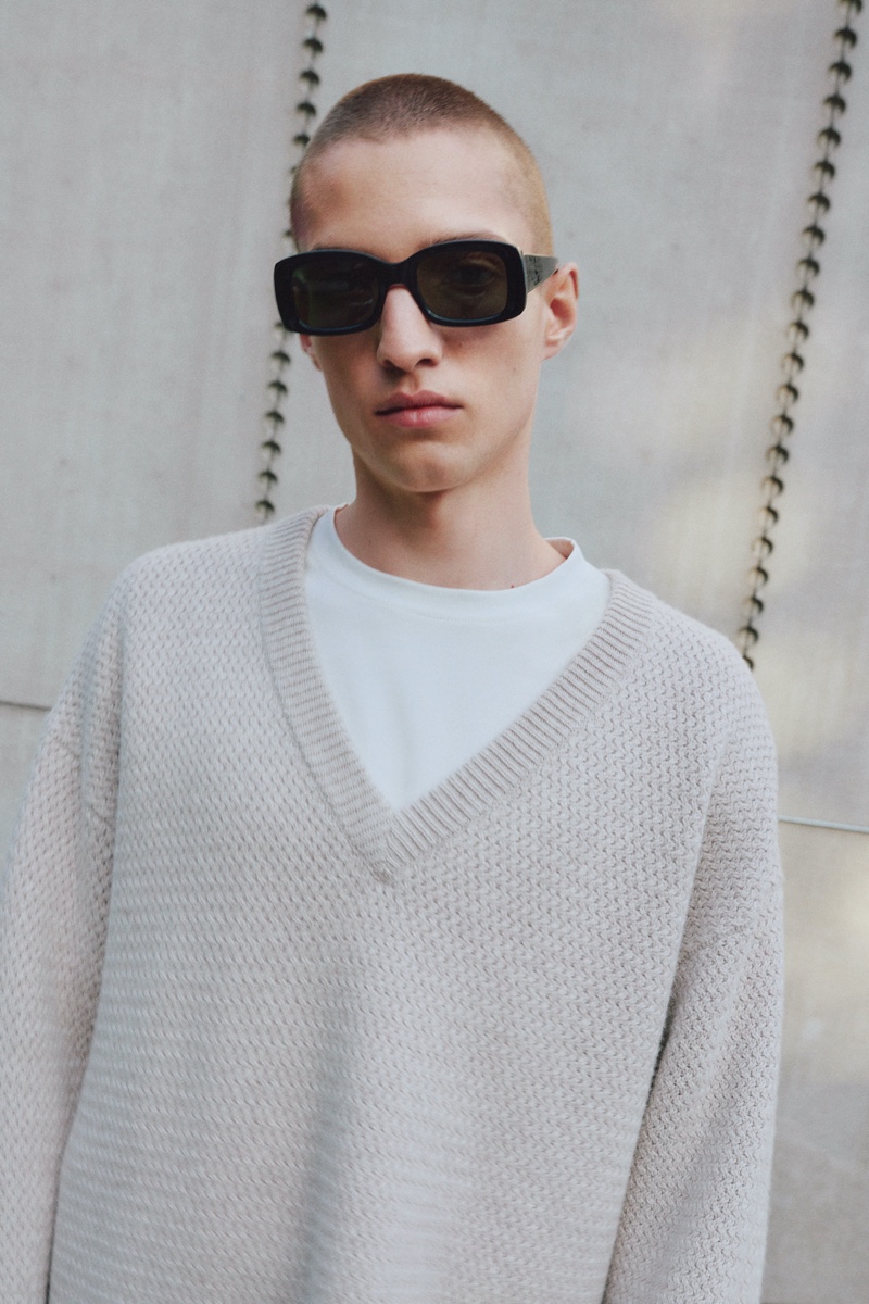 Wearing a slouchy v-neck sweater, Davyd Shyn appears in Filippa K's spring-summer 2022 men's campaign.
