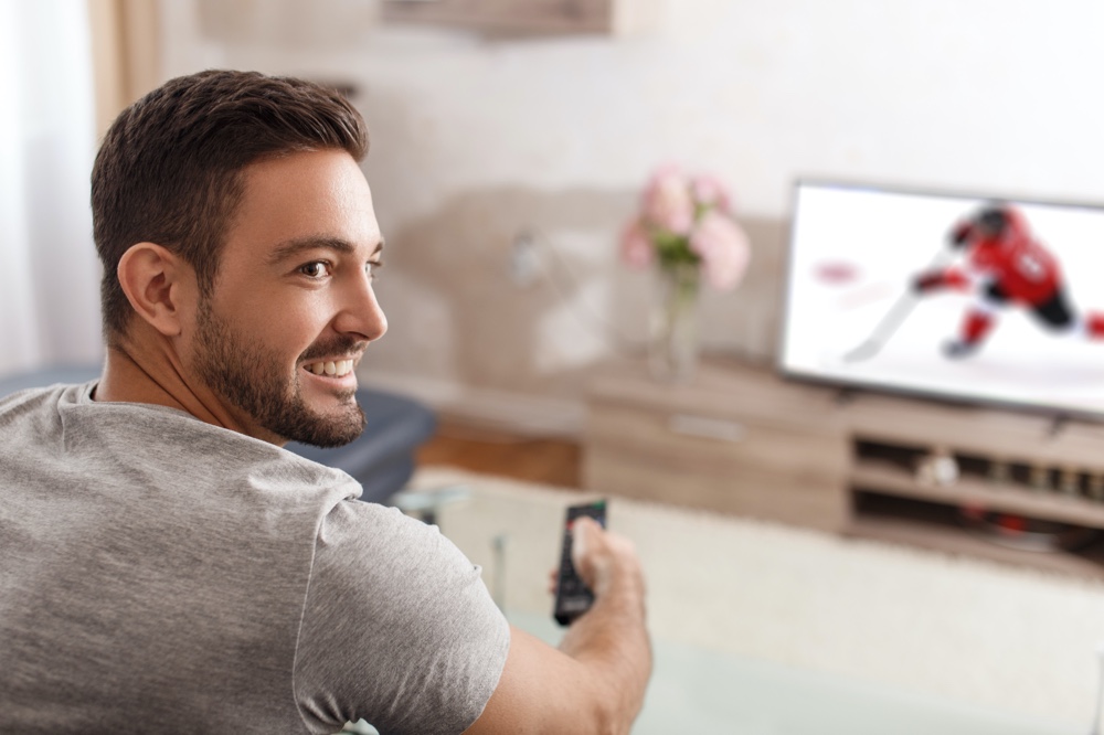 Man Watching Hockey Game on TV