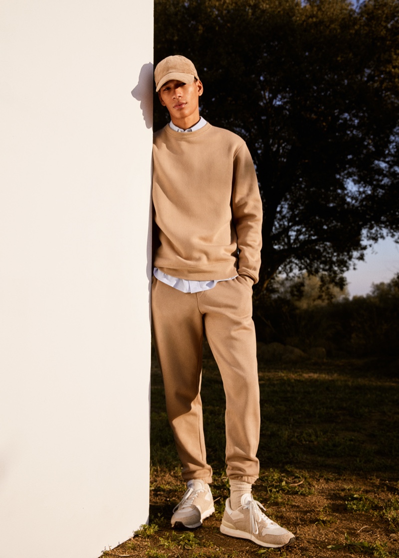Making a case for monochromatic style, Hamady Hirailles models a matching sweatshirt and joggers from Mango with a corduroy cap.