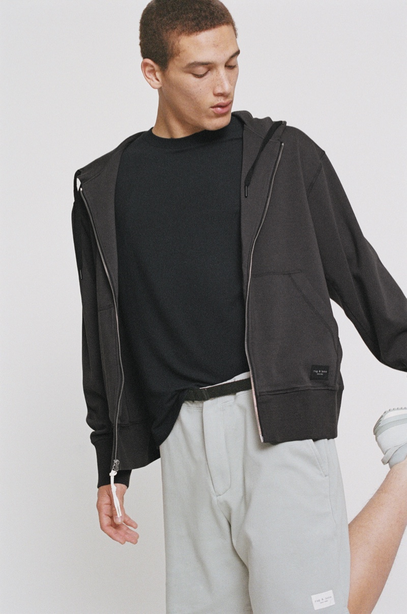 Embracing sporty style, Marco Pickett models a Rag & Bone sweater with a cotton hoodie and shorts.