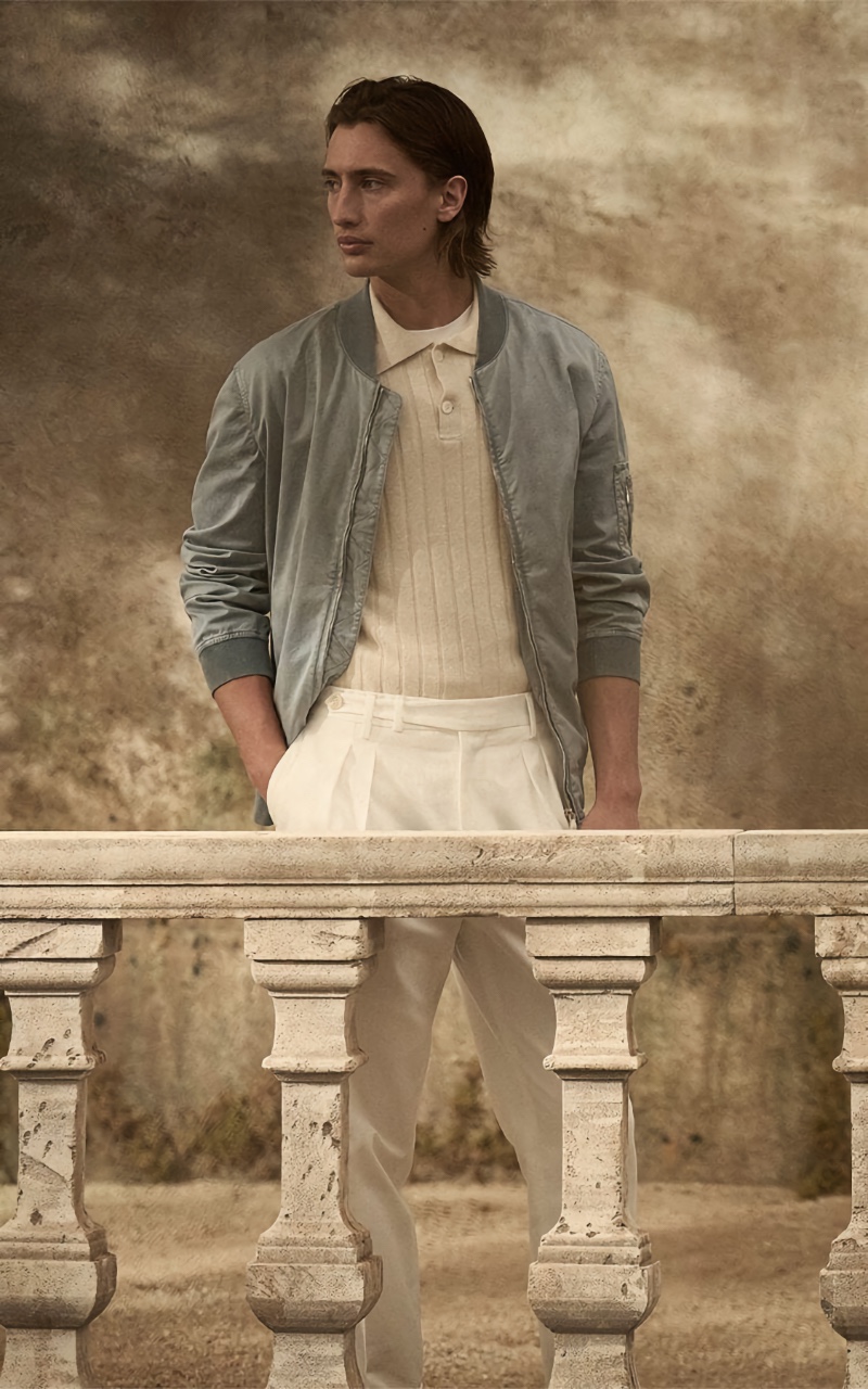 James Turlington embraces neutrals, wearing a Brunello Cucinelli bomber jacket over a ribbed polo with pleated trousers.