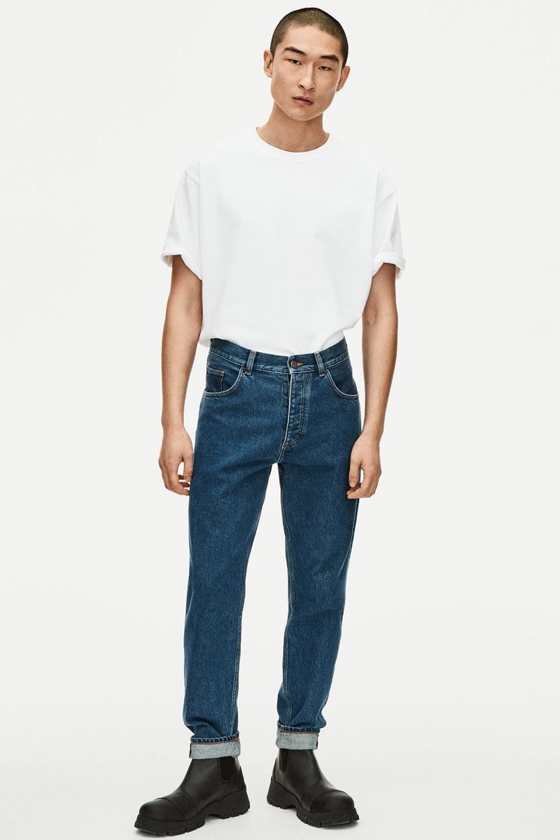 Sang Woo Kim embraces classic style in a white t-shirt with blue wash jeans for COS spring 2022 denim campaign.