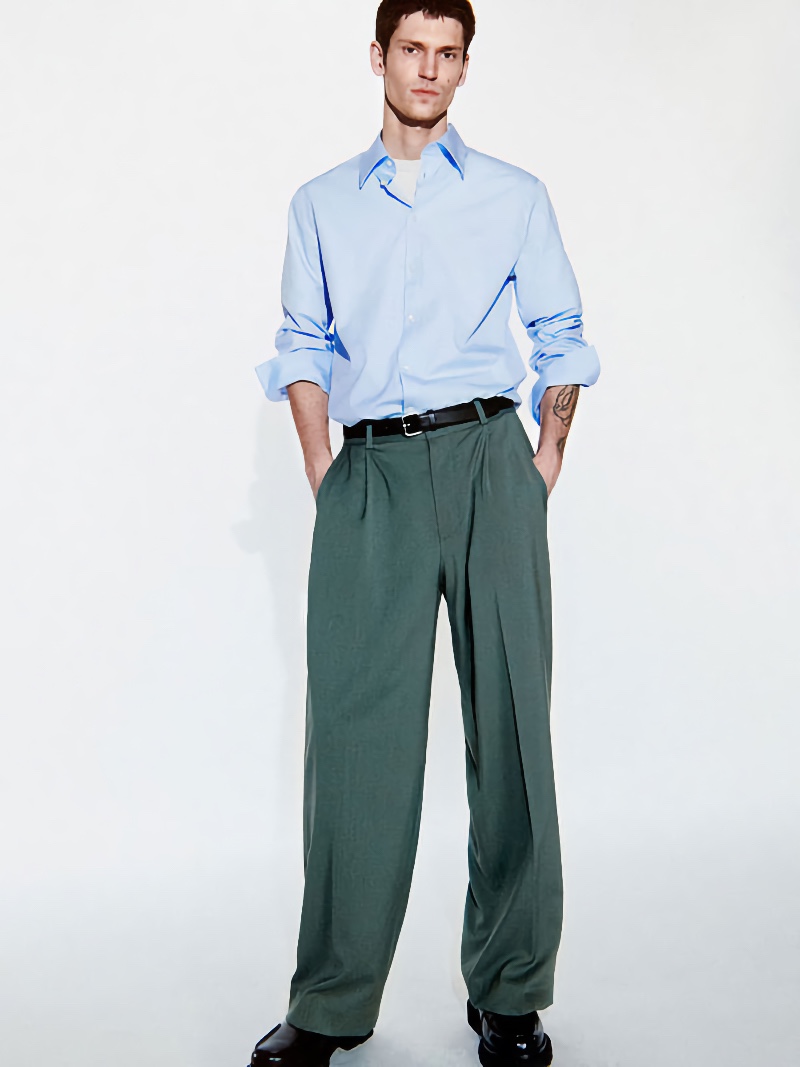 Justin Eric Martin wears a light blue dress shirt with wide-cut trousers by COS.