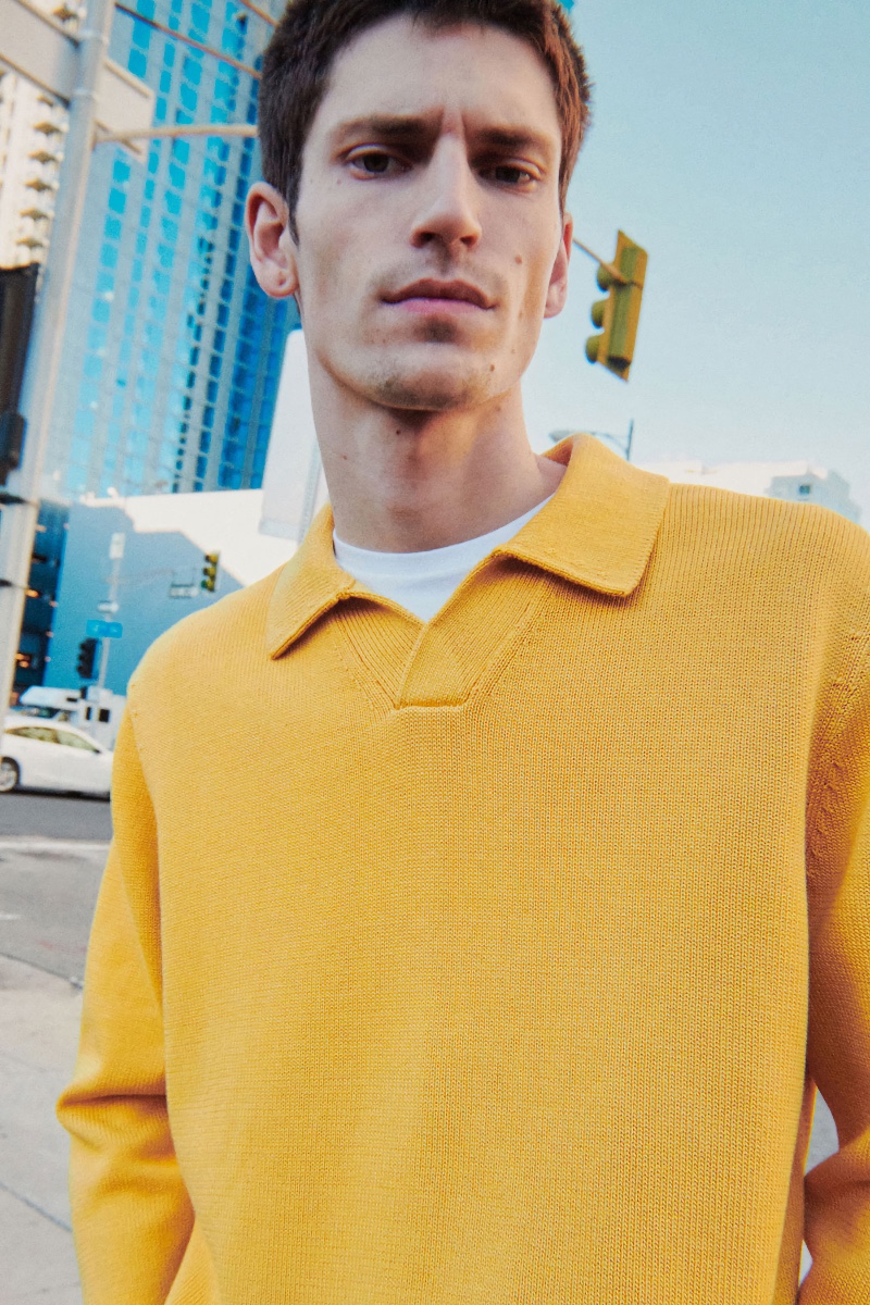 Embracing a bright moment, Justin Eric Martin models a yellow collared pullover knit from COS.